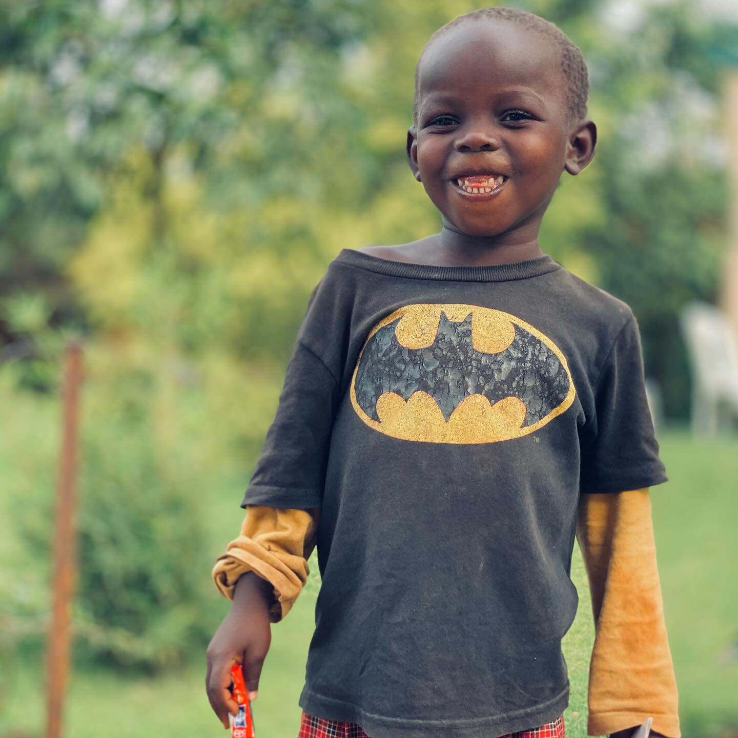 A smiling boy in a Batman shirt